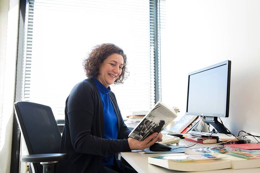 Halleh zit op haar werkplek achter de computer