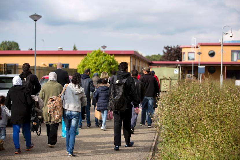 Vluchtelingen lopen naar het asielzoekerscentrum