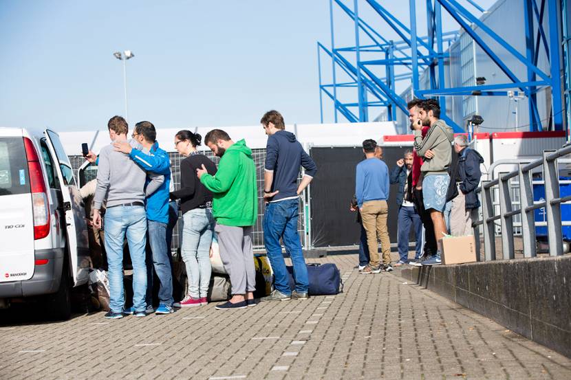 Vluchtelingen stappen in een busje naar de noodopvang