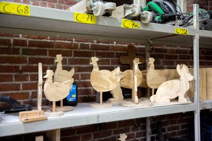 COA-huismeester Ton Reinartz maakt houten kippen die op een plank staan