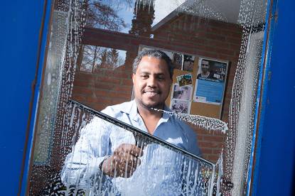 Schoonmaker kijkt door het glas heen die hij schoon maakt