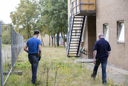 Medewerkers lopen een inspectieronde over het terrein van AZC Laren