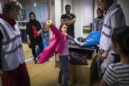 Vrijwilligers zijn bezig met uitdelen van kledingpakketten aan vluchtelingen